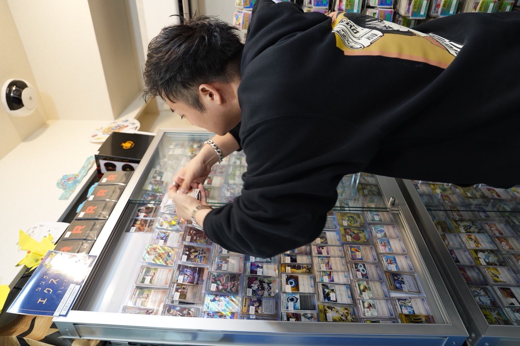 ショーケースのカードを扱う店主